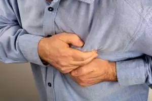 man gripping chest in pain