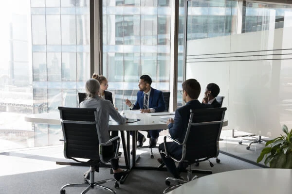 Office table in high rise office building with people in suits