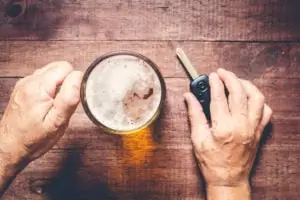 guy holding a car key and about to have a beer