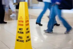 wet floor sign with people walking by