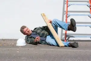 a worker lying on the ground after falling off a ladder