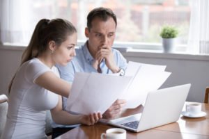 stressed young couple looking over their bills