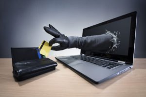 arm reaching through a laptop to grab a credit card