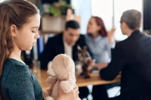 parents arguing in the background with their child in the foreground