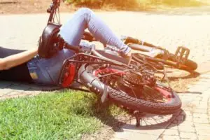 woman laying on the ground with her bike