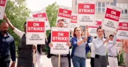 Union workers in the street holding up signs as they attempt to secure a wage increase.