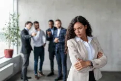 Woman in a white collared shirt being harassed, wondering if independent contractors can sue for discrimination.