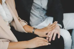 Unhappy female employee defending off hand of male colleague touching her knee. Workplace sexual harassment.