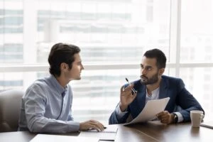 A lawyer and client meet to discuss when to hire an employment lawyer in Massachusetts.