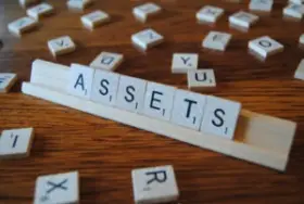 Scrabble game set spelling out "assets"