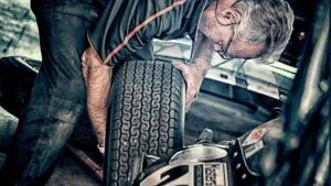car mechanic checking over a tire