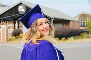 female college graduate with blue cap & gown