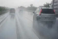 three vehicles hydroplaning on rainy roadway
