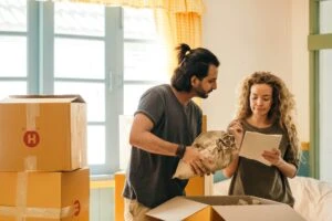 a couple unpacking boxes after moving in together