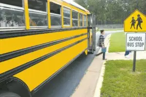 child exiting school bus at designated stop