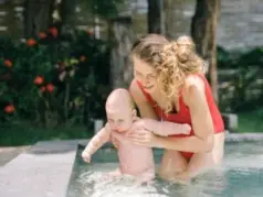 mother and baby playing in a swimming pool