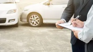 An injured man fills out the paperwork to appeal his denied car accident insurance claim. A car accident lawyer can offer valuable legal guidance.