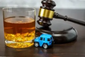 gavel with toy car and shotglass