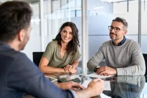 smiling couple meeting with lawyer