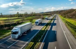 a line of trucks driving on the highway. What happens if a FedEx truck hits you?