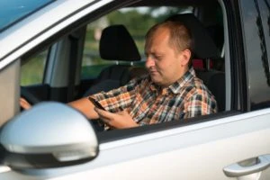 person sending a text behind the wheel