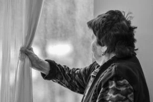 sad older woman looking out the window