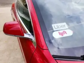 Uber and Lyft stickers on a car window