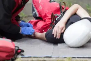 paramedic helping a construction worker on the ground
