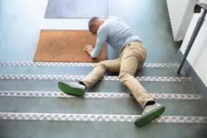 Man Lying On Staircase After Slip And Fall Accident