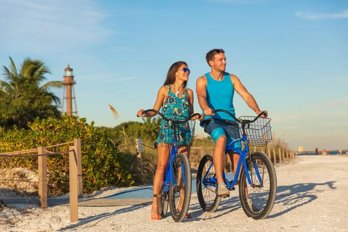 Couple riding bicycle on beach