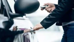 person using keys to open car door