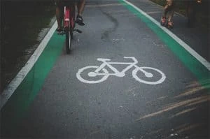 Bicycle lane on a road with a cyclist riding through and runners on the side