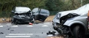 Serious car accident, head on collision, two grey cars with devastating damage on the front ends