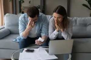 a worried couple looking at bills