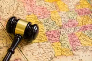 A judge’s gavel resting on a map of the United States.
