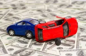model car accident atop hundred-dollar bills