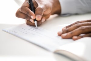 black person signing a check