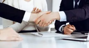 men shaking hands at a table