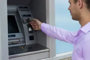 man getting cash out of an atm