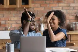 black couple high-fiving over approved loan