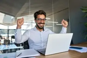 latin man happy to see his loan went through on his laptop