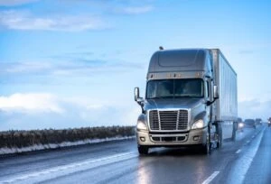 An industrial long hauler commercial truck rides down the street. A lawyer can help you gather evidence for a South Dakota truck accident claim if you suffered damage in the crash.