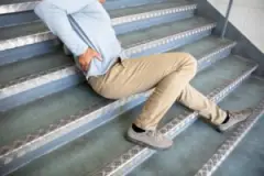 A man on the stairs after slipping and falling. In this situation, you can hire a Jacksonville slip-and-fall accident lawyer.