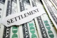 The word ‘settlement’ is placed over a few hundred dollar bills. Are personal injury settlements taxable