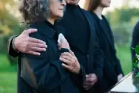 man comforting woman at a funeral