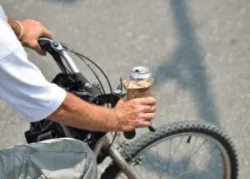 A man riding a bicycle with an alcoholic beverage wonders if he can get a DUI on a bicycle in Florida.