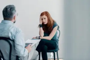 A female patient in distress while speaking with a male therapist