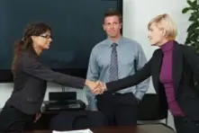 Two woman shaking hands that are in agreeance