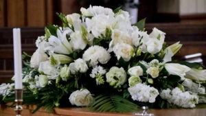 a casket with roses surrounded by candles