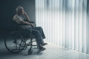 elderly Asian man sitting in a wheelchair